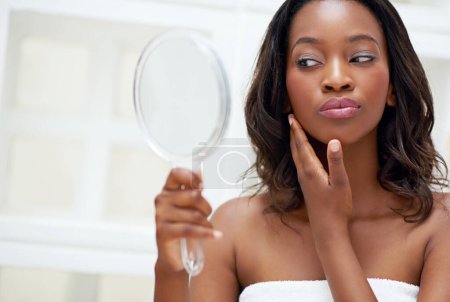 Photo for Her skin is softer than satin. a beautiful young woman looking at herself in small mirror - Royalty Free Image