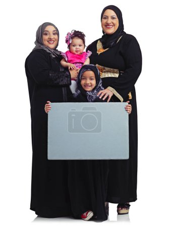 Photo for Weve got a lot to say. Studio portrait of the female members of a muslim family holding up a blank sign isolated on white - Royalty Free Image