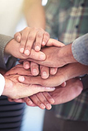 Photo for Lets do this as a team. Closeup shot of a group of coworkers with their hands in a huddle - Royalty Free Image