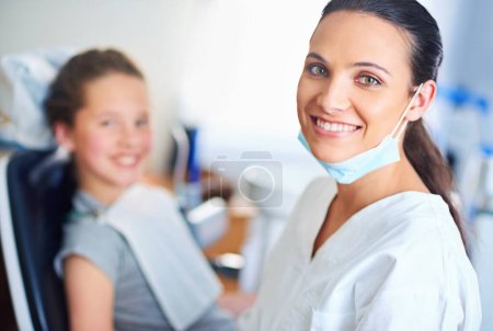 Téléchargez les photos : Deux sourires parfaits. Portrait d'une dentiste et d'un enfant dans un cabinet de dentiste - en image libre de droit