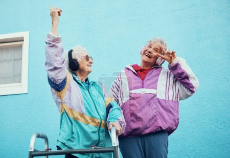 Senior, music and disability with a woman friends outdoor in a city having fun together with a peace sign hand gesture. Freedom, retirement and happy with a mature female and friend bonding outside.