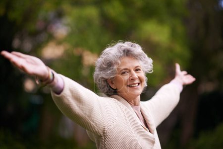 Téléchargez les photos : Retraité et se sentant incroyable. Portrait d'une femme âgée souriante debout dehors les bras levés - en image libre de droit