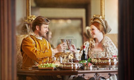 Téléchargez les photos : C'est bon d'être royal. un couple noble trinquant en mangeant ensemble - en image libre de droit