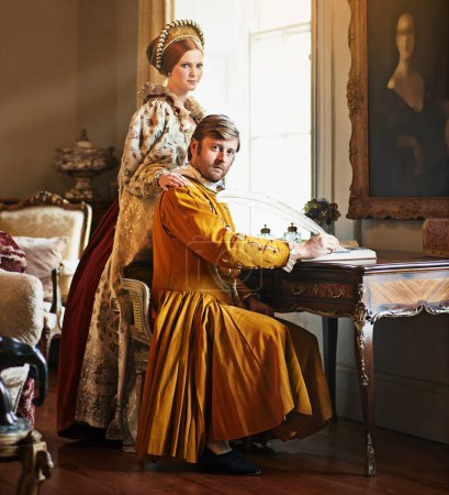 Foto de Una conspiración está en marcha. Retrato de una pareja aristocrática escribiendo una carta en una mesa adornada - Imagen libre de derechos