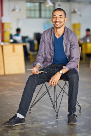 Foto de Tomando un descanso de la tableta. Retrato de un joven guapo usando una tableta digital en una oficina - Imagen libre de derechos