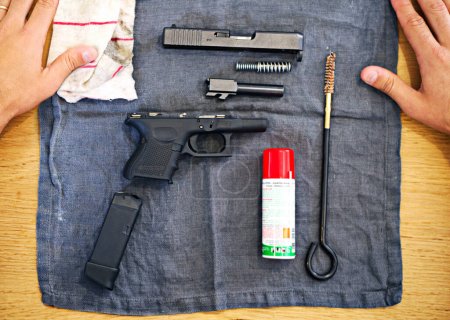Téléchargez les photos : Outils essentiels pour chaque propriétaire d'arme à feu. Un coup de fusil démonté couché sur une table - en image libre de droit