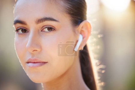 Photo for Face portrait, earphones and woman in nature streaming music, radio or podcast. Sports, fitness and female from Canada outdoors listening to audio, song or sound track and getting ready for training - Royalty Free Image