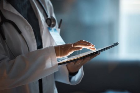 Telemedizin, digitales Tablet und Arzthände für Krankenhausinnovationen, Softwaremanagement und Ergebnisupdate am dunklen Arbeitsplatz. Gesundheitswesen, Kardiologie und Telekommunikationsmedizin mit Technologie.
