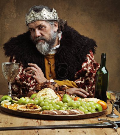 Foto de Es solitario en la parte superior. Un rey maduro festejando solo en una sala de banquetes - Imagen libre de derechos