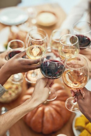 Photo for Wine, cheers and glasses at christmas toast, holiday celebration with food, friends and family together. Hands, wine glasses and friendship, celebrate diversity at dinner party with men and women - Royalty Free Image