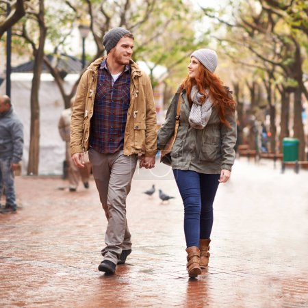 Photo for Their love warms up the winter chill. a happy young couple walking through an urban area together - Royalty Free Image