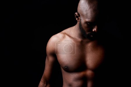Photo for Inner calm and outer strength. a muscular man looking down isolated on black - Royalty Free Image