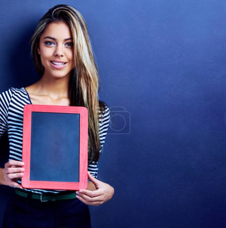 Photo for Get your message out there. an attractive young woman holding a chalkboard - Royalty Free Image