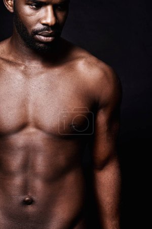 Foto de Reflexionando sobre perfección muscular. Estudio de un hombre musculoso sin camisa aislado en negro - Imagen libre de derechos