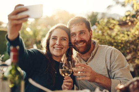 Téléchargez les photos : Vin, téléphone et couple prennent un selfie avec un toast à un mariage heureux et partager du contenu romantique sur les médias sociaux. Femme sourit en prenant des photos à un rendez-vous avec un beau partenaire boire du champagne. - en image libre de droit