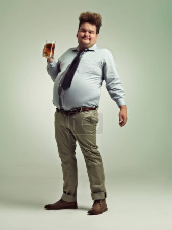 Photo for Work hard, play hard. an overweight man celebrating while holding a pint of beer - Royalty Free Image