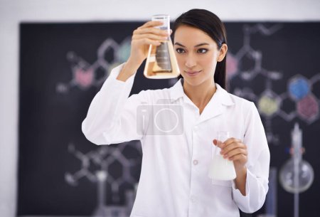 Photo for The formula is complete. a female scientist observing liquid in a conical beaker - Royalty Free Image