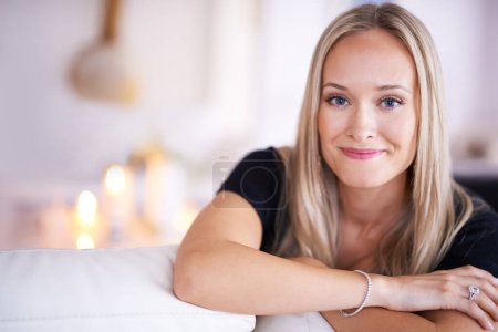Photo for Home is where my heart is. Portrait of a young blonde woman sitting on her sofa at home - Royalty Free Image
