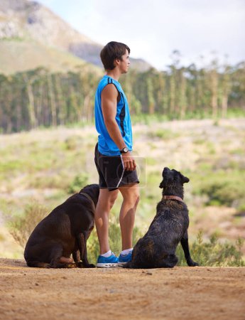 Photo for Dogs need their exercise too. a sporty man standing with his dog in the forest - Royalty Free Image