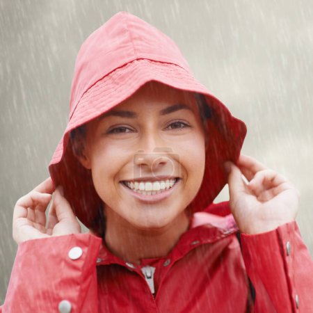 A little rain wont get me down. an attractive young woman standing in the rain