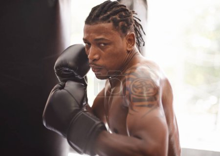 Photo for Take your best shot. Portrait of a young boxer practicing in a gym - Royalty Free Image