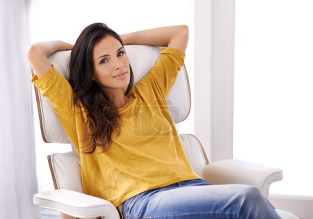 Téléchargez les photos : Du calme. Une femme se relaxant sur une chaise avec les mains derrière la tête - en image libre de droit