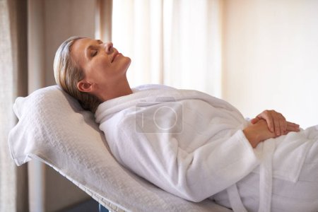 Foto de Disfrutando de un día de mimos. una mujer en un spa de día relajándose en una mesa de masaje - Imagen libre de derechos