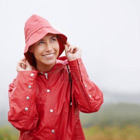 It looks like rain...but Im ready for it. an attractive young woman standing in the rain