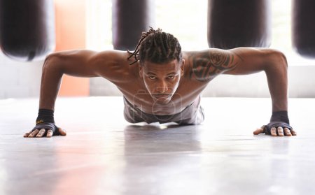 Photo for Getting ripped. Portrait of a young boxer doing pushups in a gym - Royalty Free Image