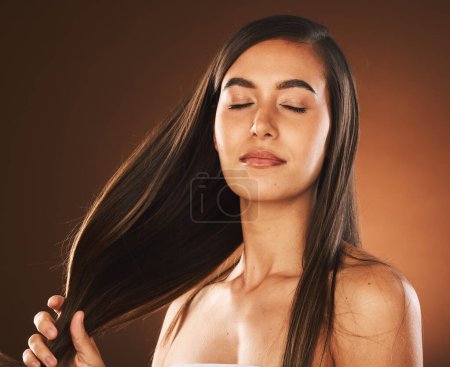 Photo for Face, beauty and hair care of woman with eyes closed in studio isolated on a brown background. Skincare, makeup and cosmetics of healthy female model from Canada satisfied with salon hair treatment - Royalty Free Image