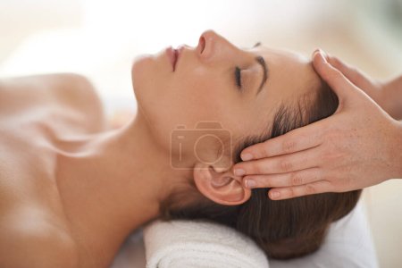 Foto de Pura relajación. Primer plano de una joven recibiendo un masaje en la cabeza en un spa - Imagen libre de derechos