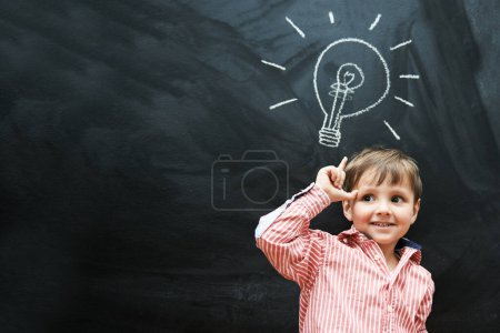 Téléchargez les photos : Il a beaucoup d'idées. Plan studio d'un jeune garçon avec une ampoule de dessin à la craie au-dessus de sa tête - en image libre de droit