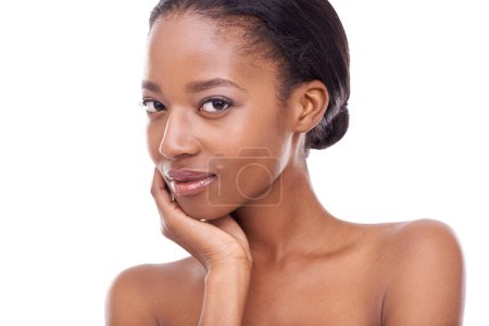 Having great skin gives me confidence. A beautiful young woman looking at the camera and touching her face