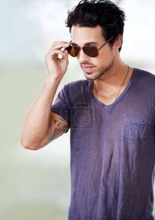 Looking trendy. Cropped view of a stylish young man wearing sunglasses