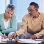 Senior black couple, taxes and home with laptop, documents or focus in home for family finance. Elderly, woman and man with computer, tablet or notebook in audit, budget or planning on lounge sofa.