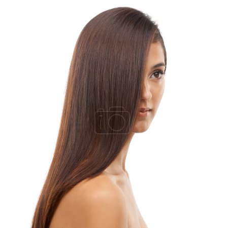 Taking care of her skin and hair. A young woman with sleek hair in studio