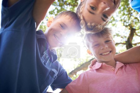 Photo for Theyre just mischief waiting to happen. Three brothers huddling together while playing outdoors in the bright sunshine - Royalty Free Image