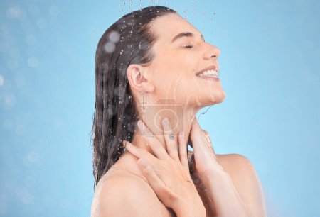 Photo for Woman shower, smile and studio with water, washing and cleaning for skincare, cosmetic health or wellness. Happy model, water drops or cosmetics for self care, skin or healthy body by blue background. - Royalty Free Image