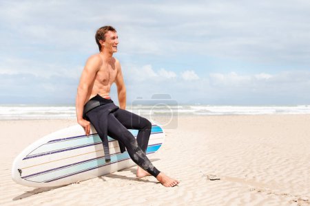 Photo for Surfing is a way of life. A young male surfer getting ready to go for a surf on a hot summers day - Royalty Free Image
