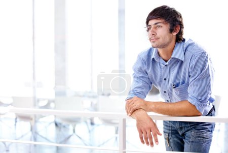 Thinking is part of the creative process. a young business professional leaning against a railing