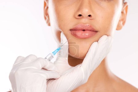 Doctor hand, botox and woman with collagen, needle and face in studio background. Plastic surgery, lip filler and cosmetic lip injection for youth for skincare, natural look and medical expert.