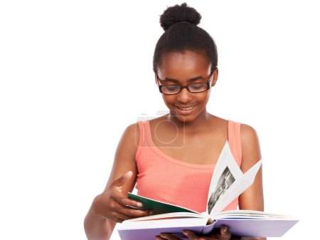 Téléchargez les photos : Les joies de la lecture. Plan studio d'une jeune afro-américaine lisant un livre et portant des lunettes isolées sur du blanc - en image libre de droit