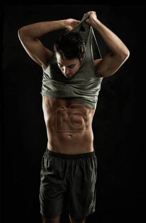 Foto de Super humeante. Musculoso joven mostrando quitándose la camisa, revelando sus abdominales - Imagen libre de derechos