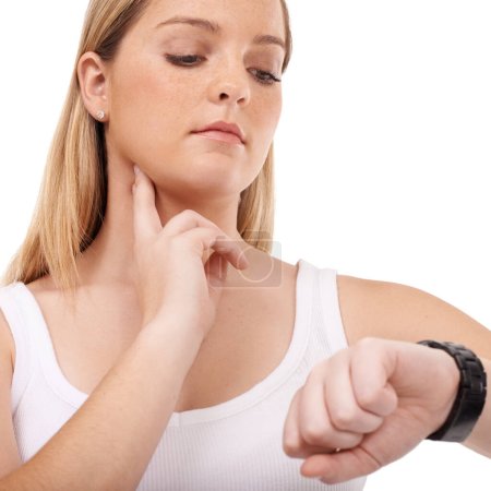 Monitoring her pulse rate carefully. Young woman taking her pulse rate against a white background