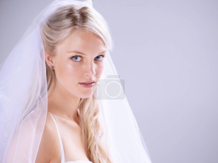 Light and love awaits her. Portrait of a beautiful young bride standing against a lilac background