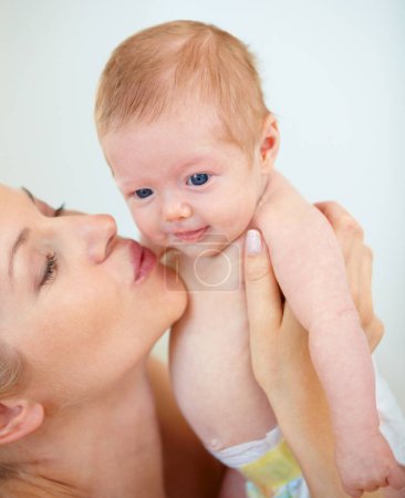 Photo pour Bisous pour bébé. Mignon gros plan d'une mère tenant son bébé près et lui donnant un baiser - image libre de droit