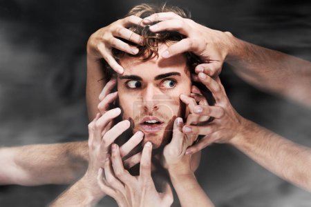 Photo for They all want him. A mans head being grabbed from all sides by many hands - Royalty Free Image