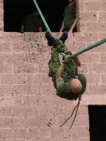 Photo for It takes strength of will to perfect this. A soldier traversing across a rope during an exercise - Royalty Free Image