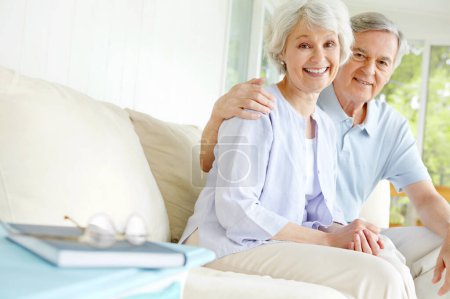 Entspannen in ihrem Wohnzimmer. Ein liebevolles Seniorenpaar genießt die Gesellschaft eines anderen im Wohnzimmer
