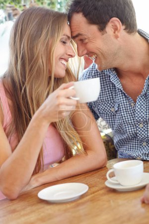 Photo pour Le bonheur est une tasse de café partagée avec celui que j'aime. Un beau jeune couple dégustant une tasse de café au restaurant - image libre de droit